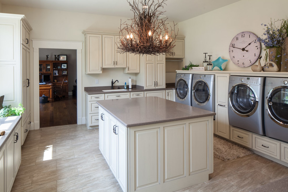 Mid-sized beach style utility room in Other with an undermount sink, raised-panel cabinets, beige cabinets, solid surface benchtops, beige walls, porcelain floors and a side-by-side washer and dryer.