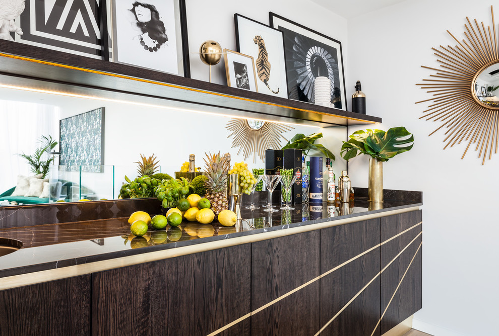 Photo of a mid-sized contemporary single-wall home bar in London with flat-panel cabinets, dark wood cabinets, marble benchtops, mirror splashback, light hardwood floors and beige floor.