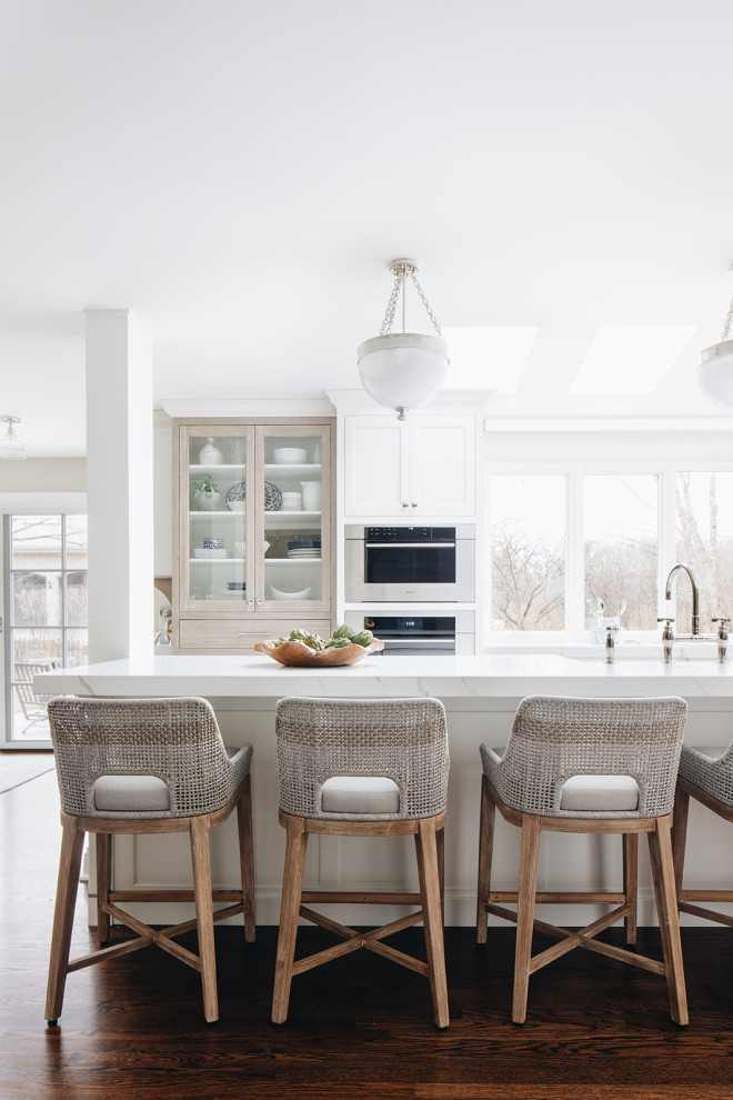 Example of a mid-sized transitional dark wood floor and brown floor eat-in kitchen design in Chicago with a farmhouse sink, beaded inset cabinets, white cabinets, quartz countertops, paneled appliances, an island and white countertops