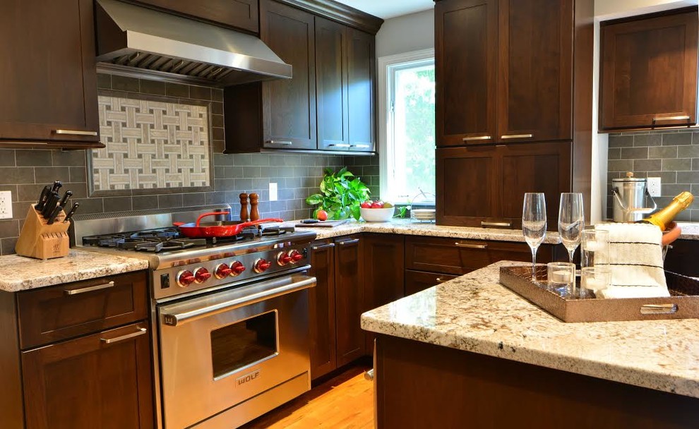 Open concept kitchen - mid-sized transitional l-shaped light wood floor and beige floor open concept kitchen idea in Orlando with an undermount sink, shaker cabinets, dark wood cabinets, granite countertops, gray backsplash, ceramic backsplash, stainless steel appliances and an island