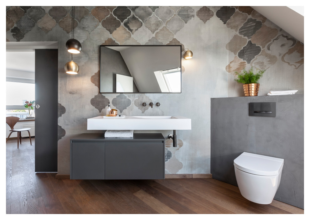 Mid-sized traditional 3/4 bathroom in Frankfurt with flat-panel cabinets, grey cabinets, a curbless shower, a two-piece toilet, grey walls, dark hardwood floors, a console sink, solid surface benchtops, brown floor, an open shower, white benchtops, a niche, a single vanity, a floating vanity, wallpaper and wallpaper.