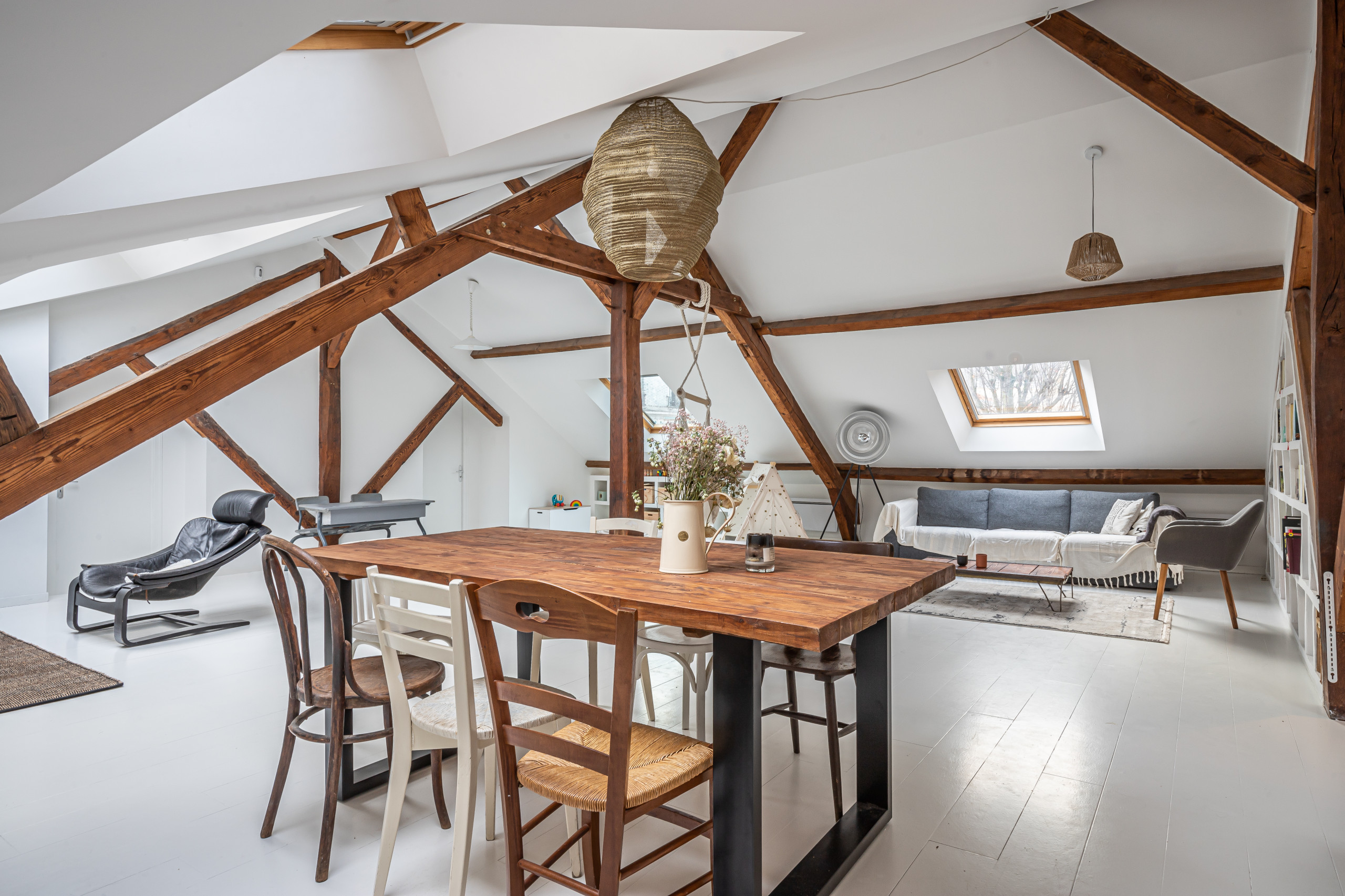 Huge cottage painted wood floor, white floor and exposed beam great room photo in Paris with white walls and no fireplace