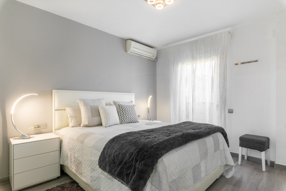 Ejemplo de dormitorio principal y gris y blanco contemporáneo de tamaño medio con paredes blancas, suelo de baldosas de cerámica y suelo gris