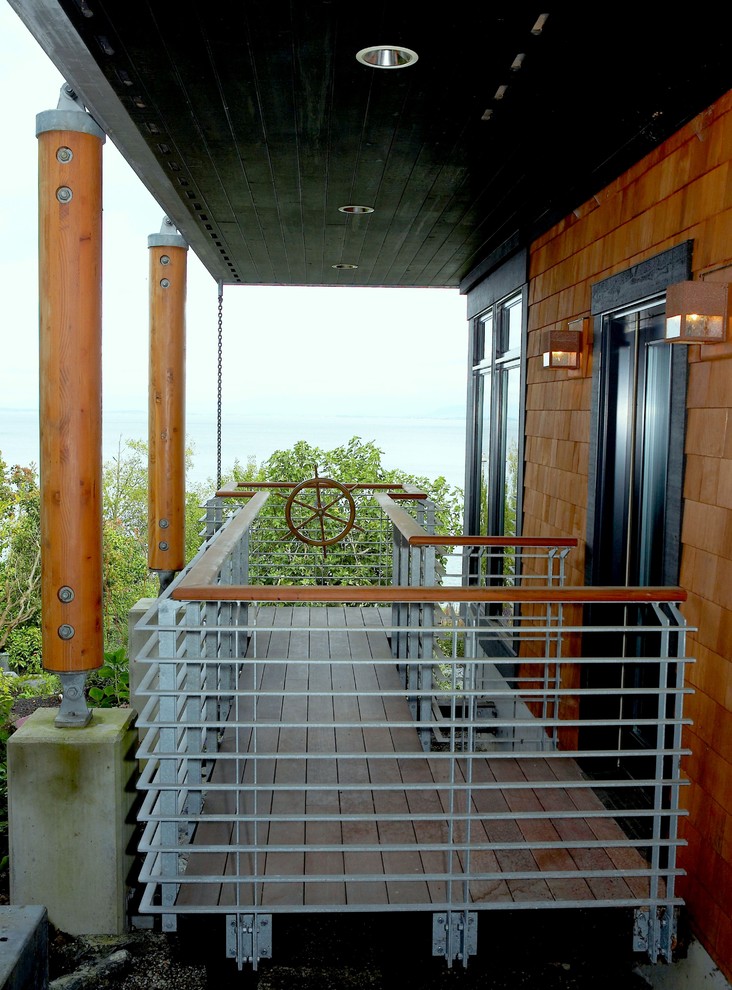 This is an example of a mid-sized transitional balcony in Seattle with a roof extension and metal railing.