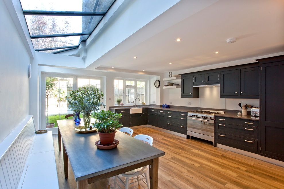 This is an example of a mid-sized transitional single-wall eat-in kitchen in London with an integrated sink, shaker cabinets, blue cabinets, quartzite benchtops, white splashback, glass tile splashback, coloured appliances, porcelain floors and no island.