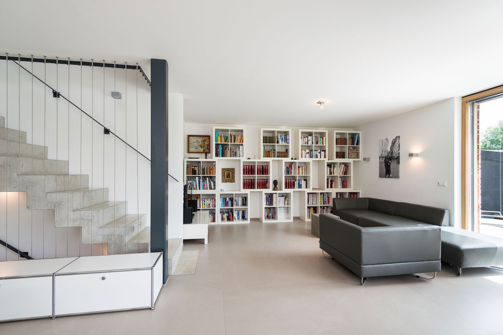 Large contemporary open concept living room in Munich with white walls and a library.