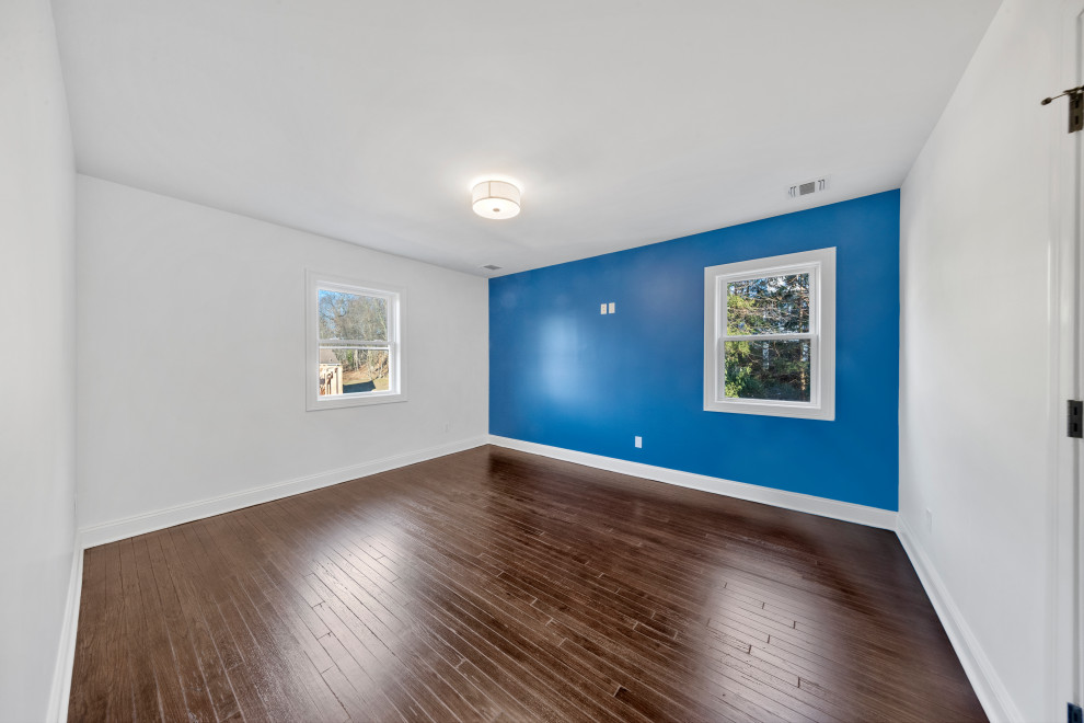 Bedroom with Bold Blue Wall and Two Windows