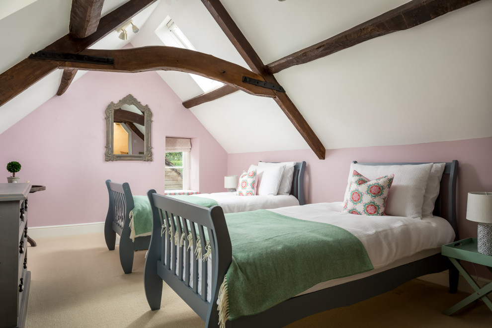 This is an example of a mid-sized country bedroom in Gloucestershire with pink walls, carpet, beige floor and vaulted.
