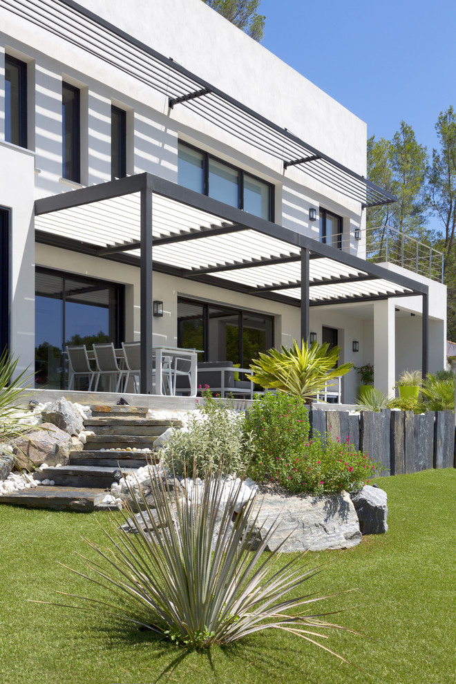 Photo of a contemporary front yard patio in Marseille with a pergola.