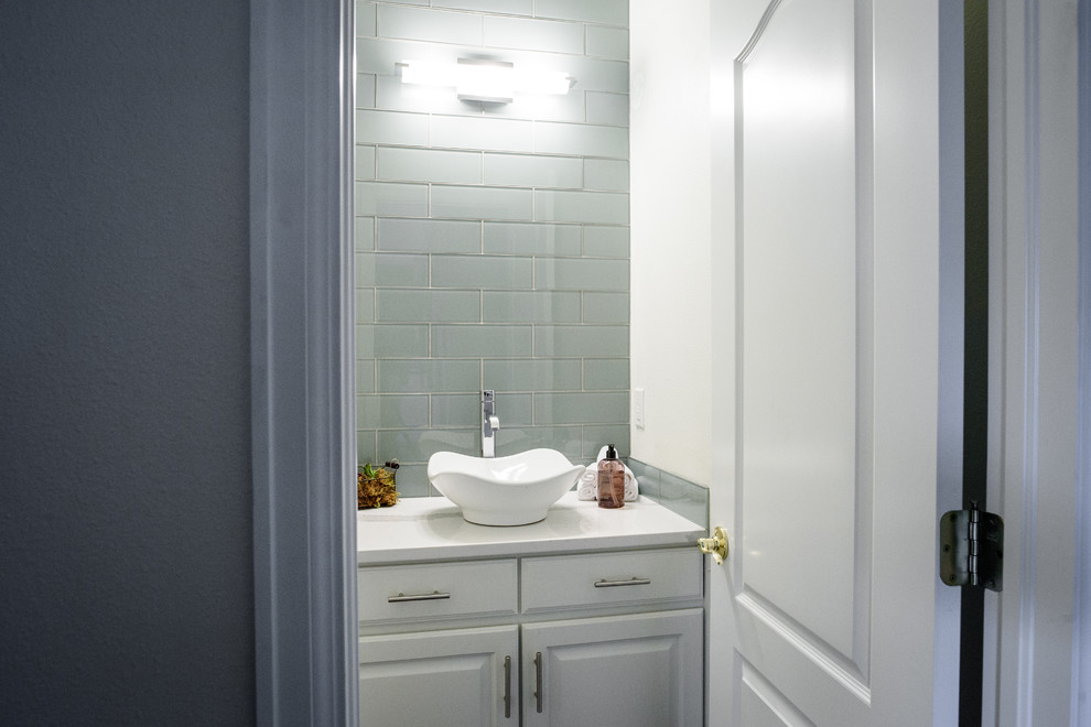 Example of a small transitional gray tile and glass tile bathroom design in Denver with raised-panel cabinets, white cabinets, a two-piece toilet, white walls, a vessel sink and quartz countertops