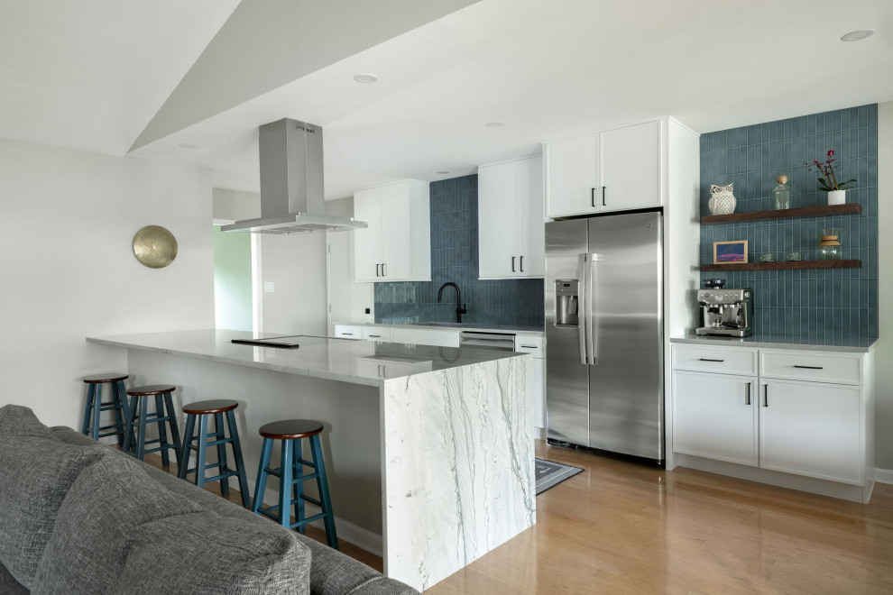 Eat-in kitchen - mid-sized transitional galley light wood floor, yellow floor and vaulted ceiling eat-in kitchen idea in Austin with an undermount sink, shaker cabinets, white cabinets, quartzite countertops, blue backsplash, subway tile backsplash, stainless steel appliances, a peninsula and gray countertops