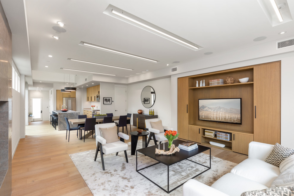 Inspiration for a contemporary open concept light wood floor and beige floor living room remodel in Los Angeles with a wall-mounted tv and white walls