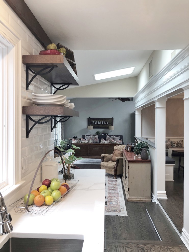 Inspiration for a huge transitional dark wood floor and brown floor eat-in kitchen remodel with an undermount sink, shaker cabinets, white cabinets, quartz countertops, white backsplash, porcelain backsplash, stainless steel appliances, an island and white countertops