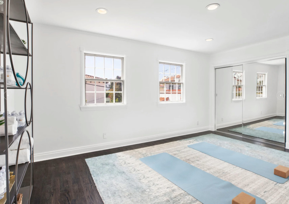 Photo of a mid-sized transitional home yoga studio in Los Angeles with white walls, dark hardwood floors and brown floor.