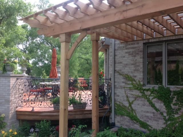 This is an example of a traditional backyard patio in Chicago with decking and a pergola.