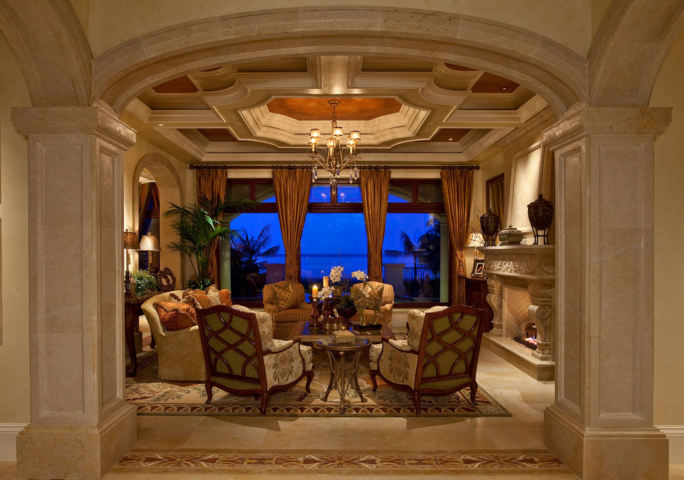 Inspiration for a mediterranean living room in Miami with beige walls, a standard fireplace and beige floor.