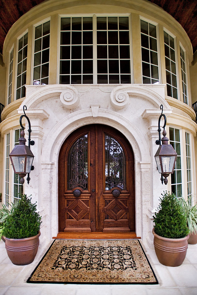 Large mediterranean front door in Atlanta with beige walls, concrete floors, a double front door and a medium wood front door.