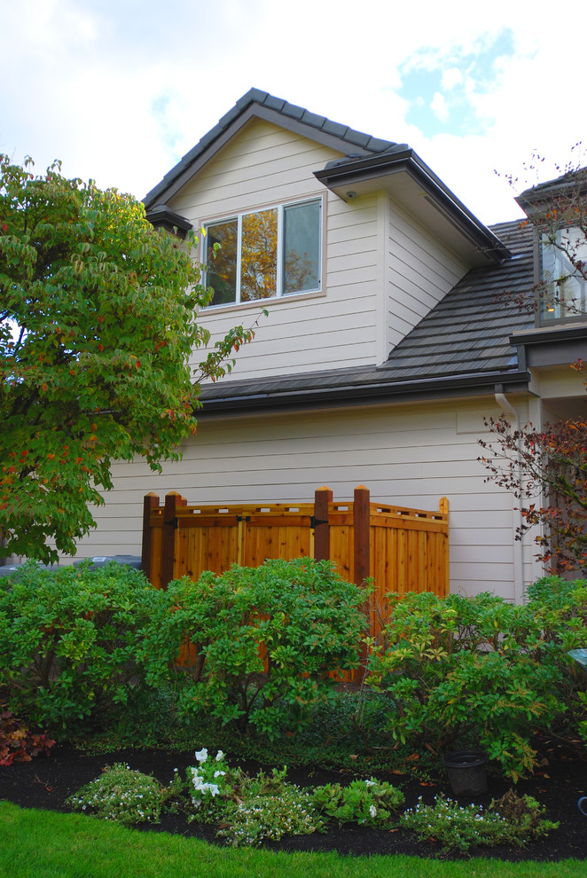Small traditional two-storey beige exterior in Other with concrete fiberboard siding and a hip roof.
