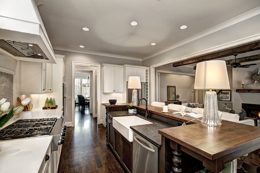 Open concept kitchen - huge transitional u-shaped dark wood floor open concept kitchen idea in Charlotte with a farmhouse sink, recessed-panel cabinets, white cabinets, gray backsplash, cement tile backsplash, stainless steel appliances and an island