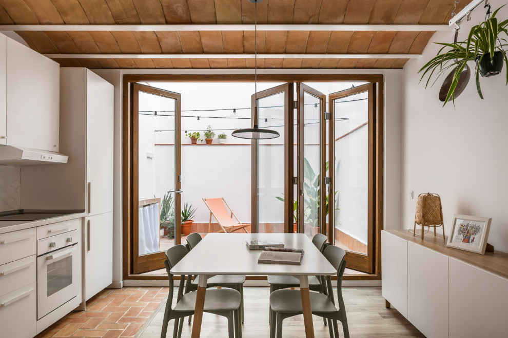 Idéer för en liten medelhavsstil matplats med öppen planlösning, med vita väggar, laminatgolv och brunt golv