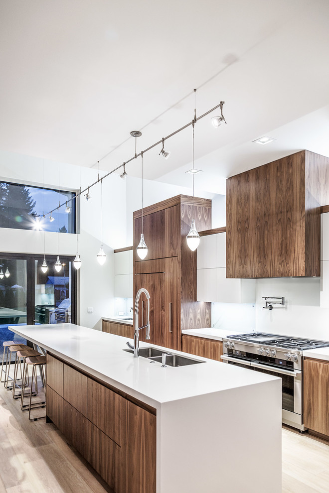This is an example of a large modern single-wall eat-in kitchen in Portland with a double-bowl sink, flat-panel cabinets, quartz benchtops, white splashback, glass sheet splashback, panelled appliances, bamboo floors, with island, beige floor and medium wood cabinets.