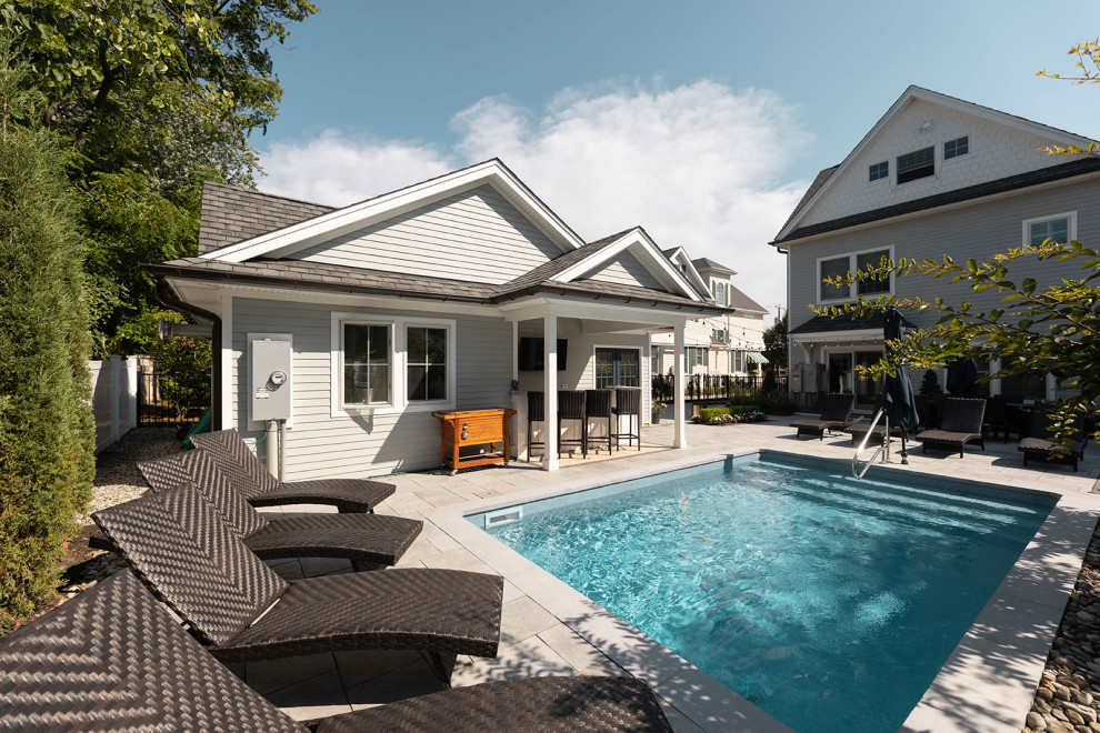 Small transitional backyard concrete paver and rectangular pool house photo in New York