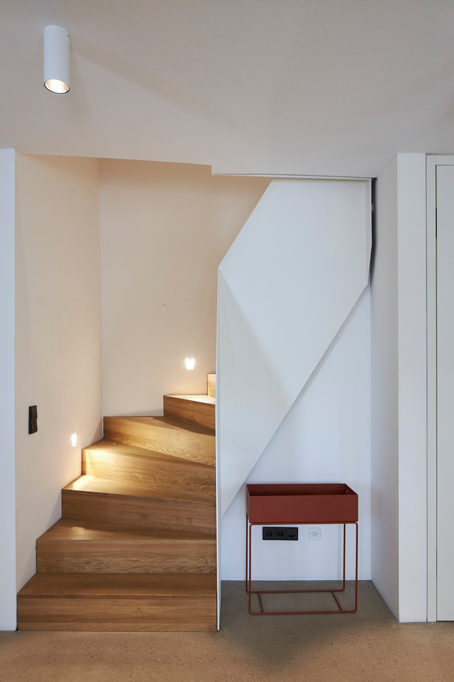 Inspiration for a modern painted wood staircase in Cologne with painted wood risers and metal railing.