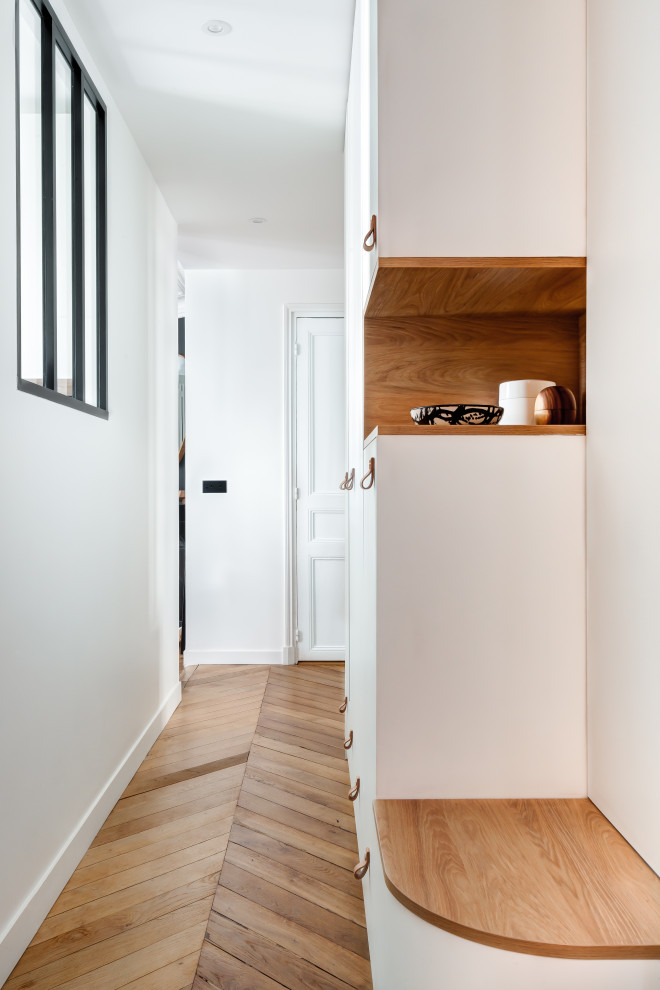 Inspiration for a mid-sized modern hallway in Paris with white walls, light hardwood floors and beige floor.