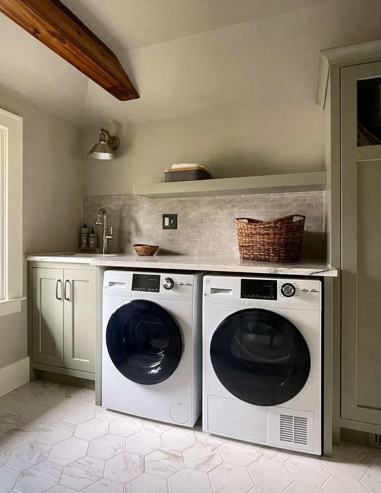 Photo of a traditional laundry room in Other with an undermount sink, shaker cabinets, green cabinets, quartzite benchtops, grey splashback, porcelain splashback, grey walls, porcelain floors, a side-by-side washer and dryer, white floor and exposed beam.