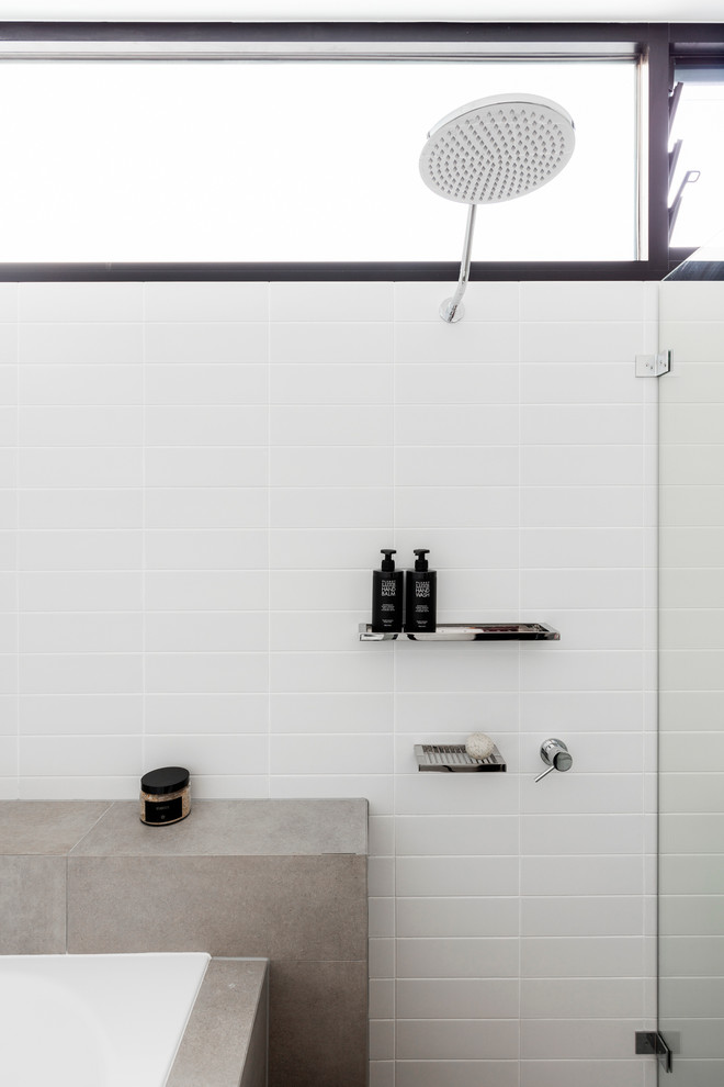 Mid-sized contemporary 3/4 bathroom in Sydney with recessed-panel cabinets, white cabinets, a drop-in tub, an open shower, a one-piece toilet, white tile, subway tile, white walls, ceramic floors, a drop-in sink and engineered quartz benchtops.