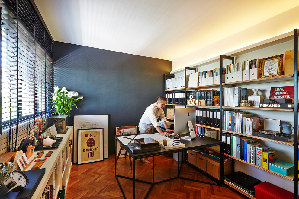 Inspiration for a mid-sized contemporary study room in Singapore with black walls and a freestanding desk.