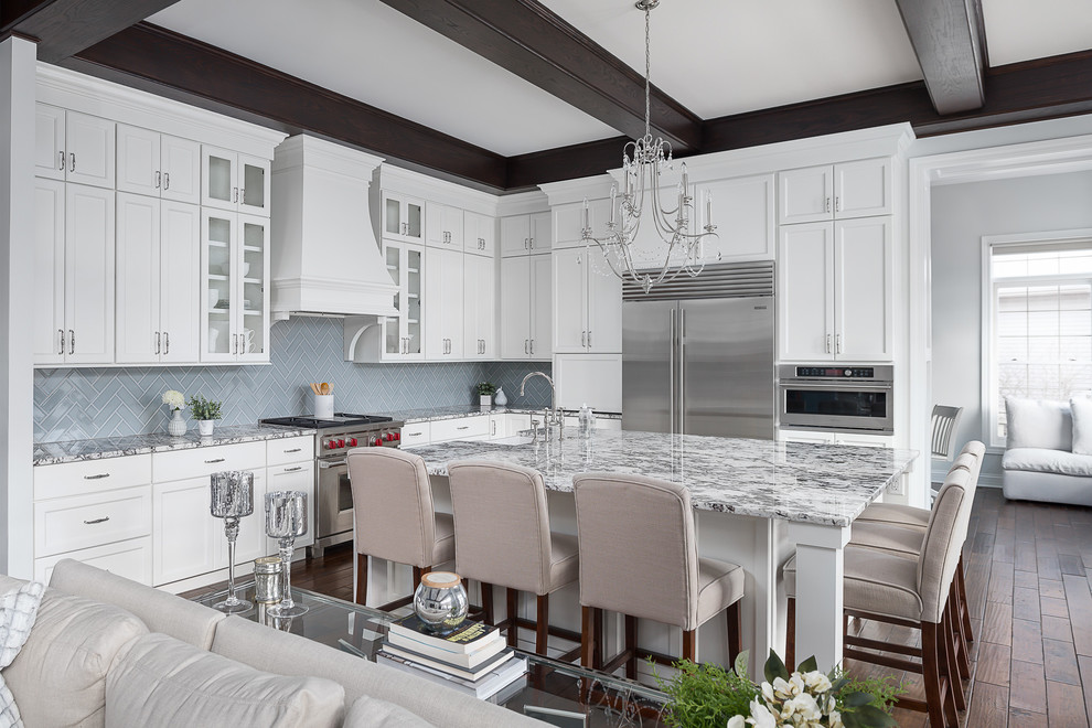 Inspiration for a large transitional l-shaped open plan kitchen in Chicago with a farmhouse sink, granite benchtops, porcelain splashback, stainless steel appliances, dark hardwood floors, with island, brown floor, multi-coloured benchtop, shaker cabinets, grey cabinets and grey splashback.