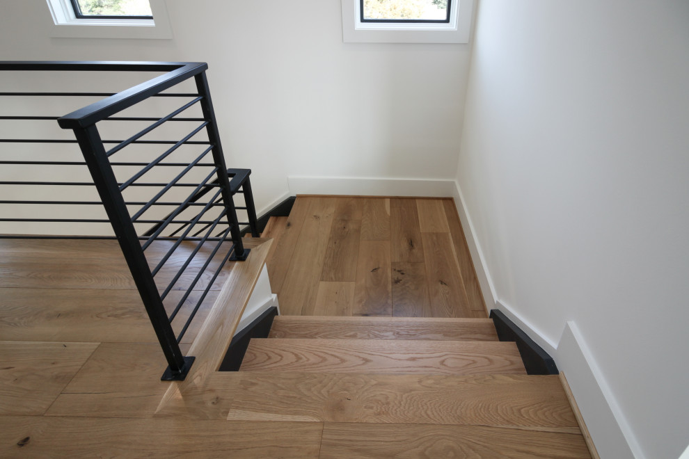 На фото: прямая лестница среднего размера в современном стиле с деревянными ступенями и металлическими перилами с
