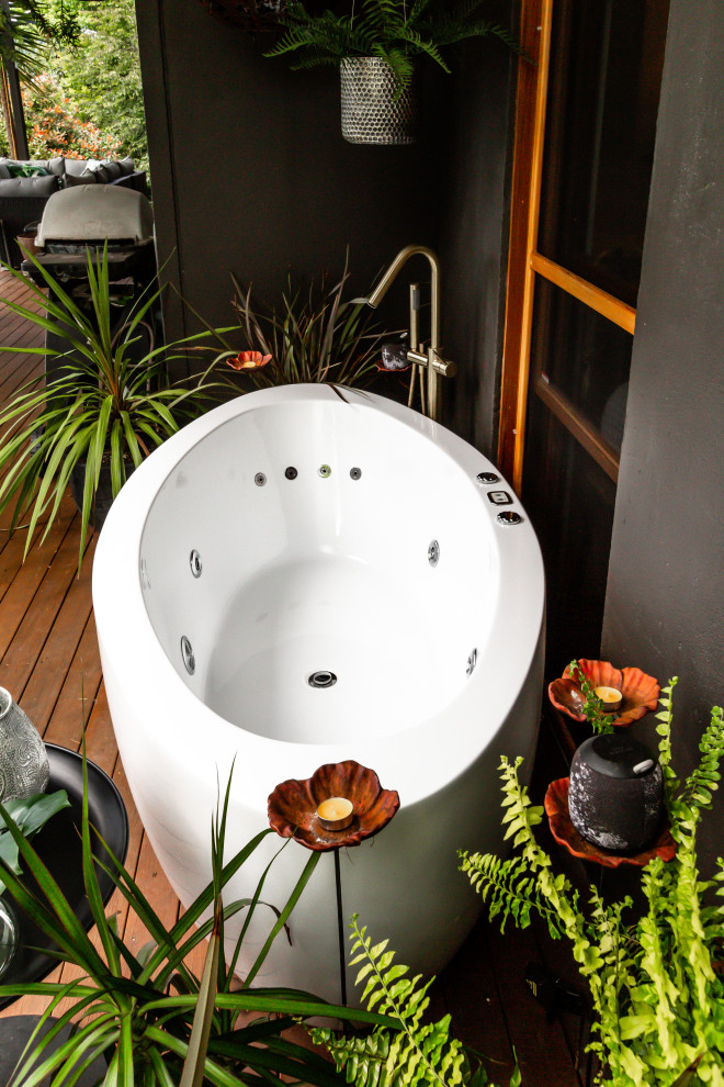 Design ideas for a mid-sized mediterranean 3/4 bathroom in Sydney with flat-panel cabinets, light wood cabinets, a freestanding tub, a corner shower, a two-piece toilet, an integrated sink, a hinged shower door, a niche, a double vanity, a floating vanity and white benchtops.