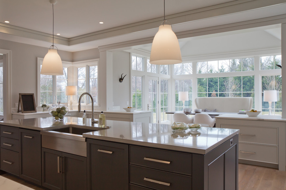 Design ideas for a large country l-shaped open plan kitchen in New York with an undermount sink, shaker cabinets, white cabinets, white splashback, stone slab splashback, stainless steel appliances, light hardwood floors and with island.