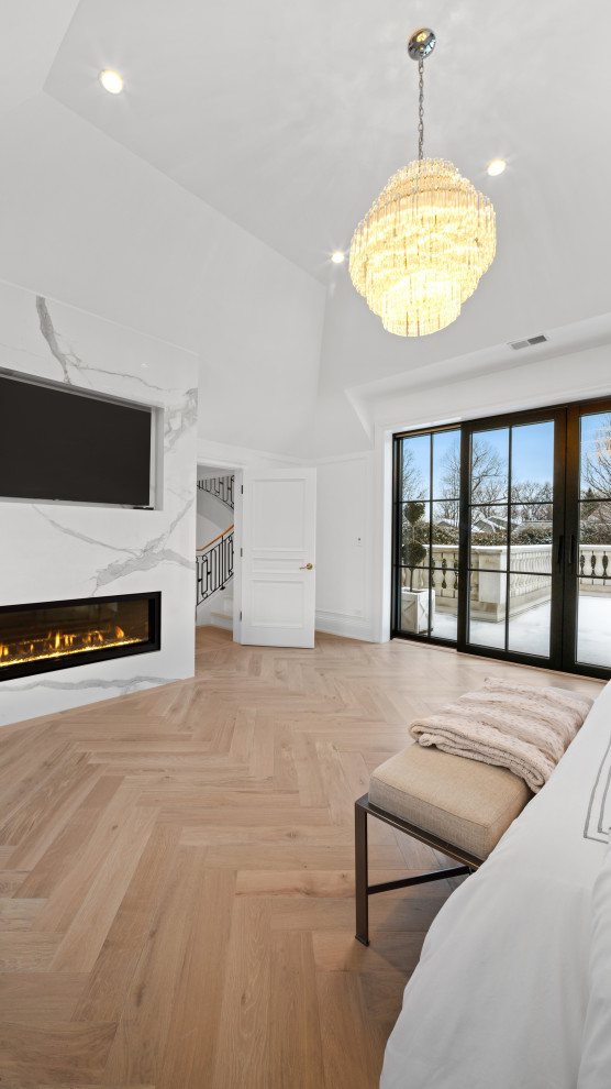 Diseño de dormitorio principal, abovedado y blanco moderno grande con paredes blancas, suelo de madera clara, chimenea lineal y marco de chimenea de piedra