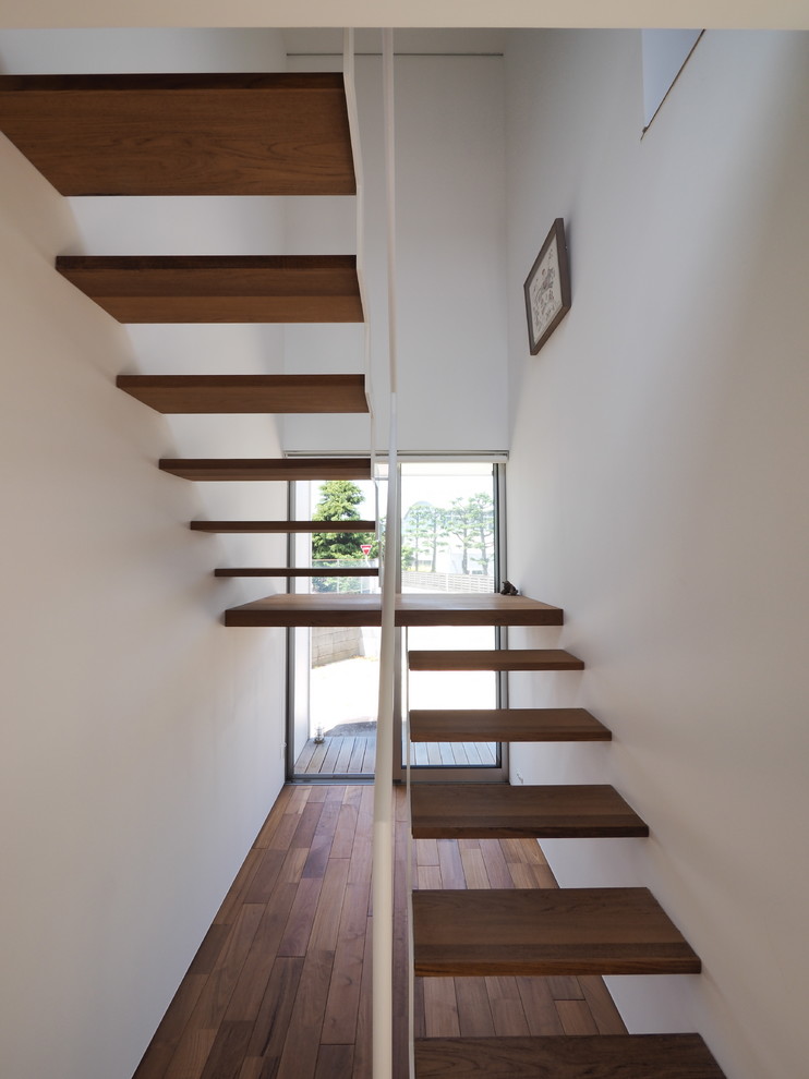 This is an example of a contemporary wood floating staircase in Other.