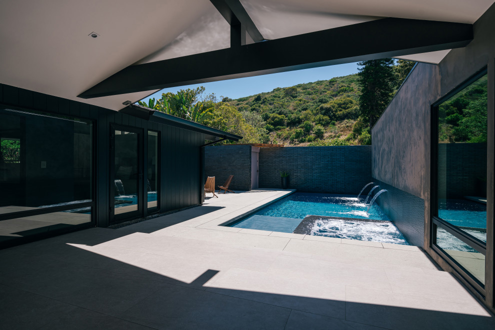 На фото: прямоугольный бассейн среднего размера на внутреннем дворе в стиле ретро с перегородкой для приватности и покрытием из бетонных плит