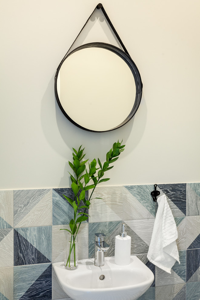 This is an example of a scandinavian powder room in Moscow with a two-piece toilet, blue tile, ceramic tile, grey walls, porcelain floors and a wall-mount sink.