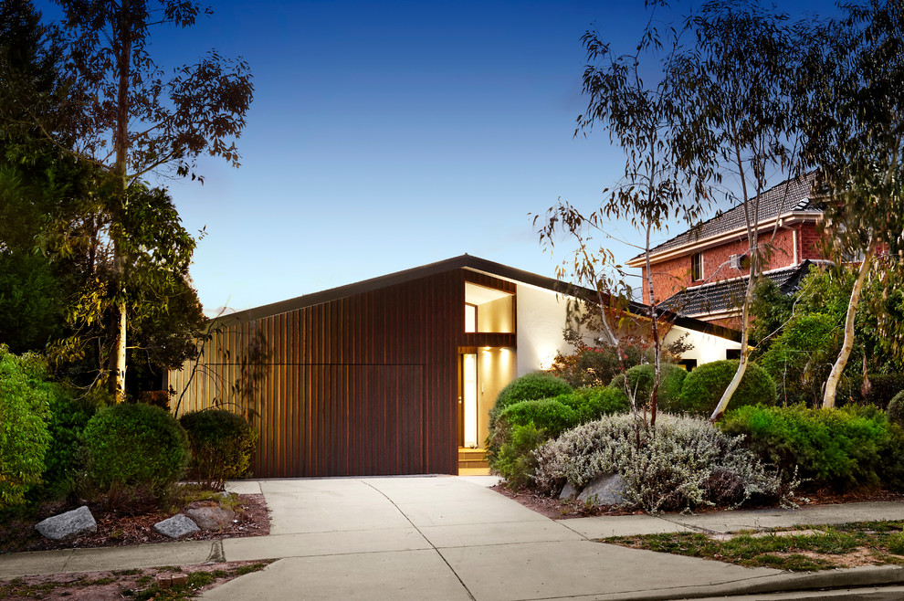 This is an example of a large contemporary split-level multi-coloured exterior in Melbourne with wood siding and a hip roof.