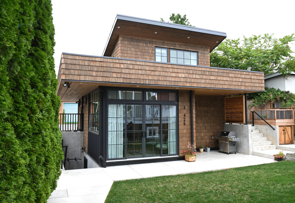 Идея дизайна: маленький, двухэтажный, деревянный, коричневый мини дом в современном стиле с односкатной крышей, крышей из гибкой черепицы, черной крышей и отделкой дранкой для на участке и в саду