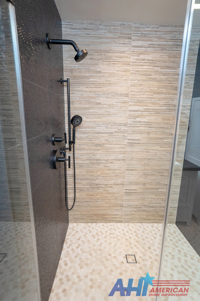 This is an example of a large modern master bathroom in Los Angeles with raised-panel cabinets, white cabinets, a corner shower, a one-piece toilet, beige tile, pebble tile, blue walls, porcelain floors, a drop-in sink, marble benchtops, white floor, a hinged shower door, black benchtops, a double vanity and a built-in vanity.