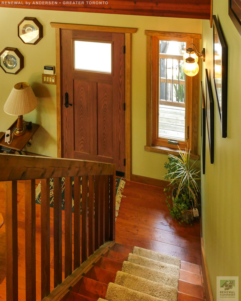 Example of a mid-sized medium tone wood floor and shiplap ceiling entryway design in Toronto with yellow walls and a medium wood front door