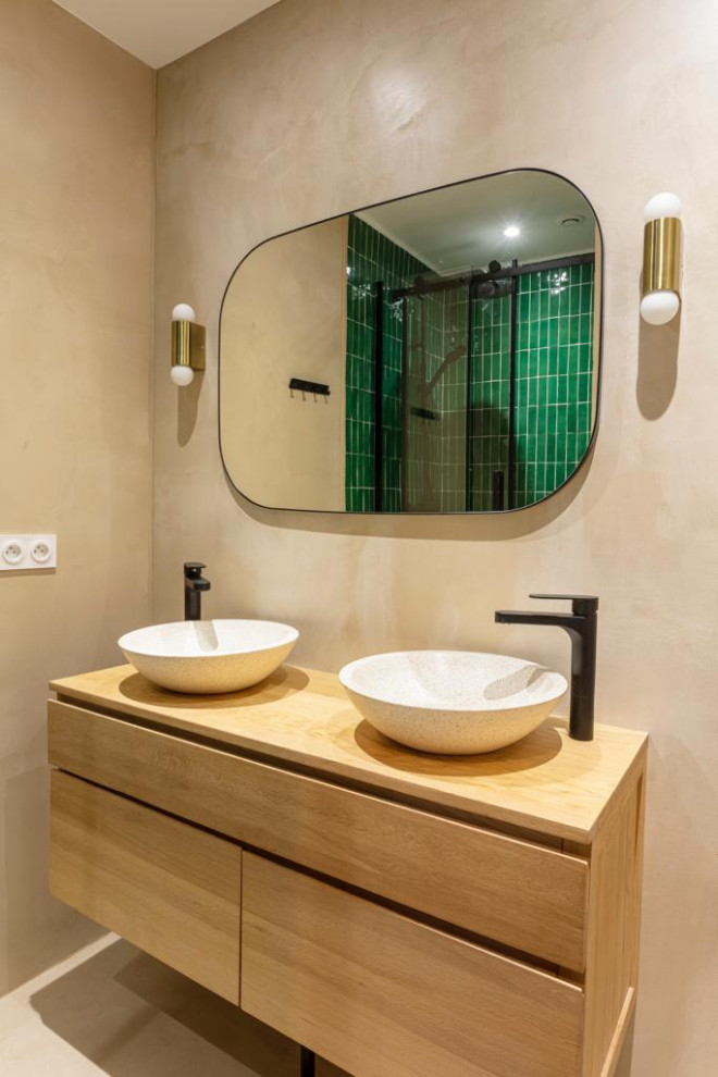 Exemple d'une salle de bain principale chic en bois clair de taille moyenne avec une douche d'angle, un carrelage vert, un carrelage métro, un mur beige, sol en béton ciré, une grande vasque, un sol beige, une cabine de douche à porte coulissante, une porte coulissante, meuble double vasque et meuble-lavabo suspendu.