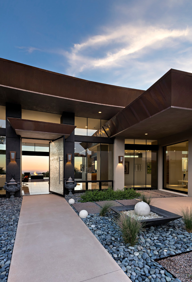 Large modern one-storey adobe beige exterior in Phoenix with a flat roof.