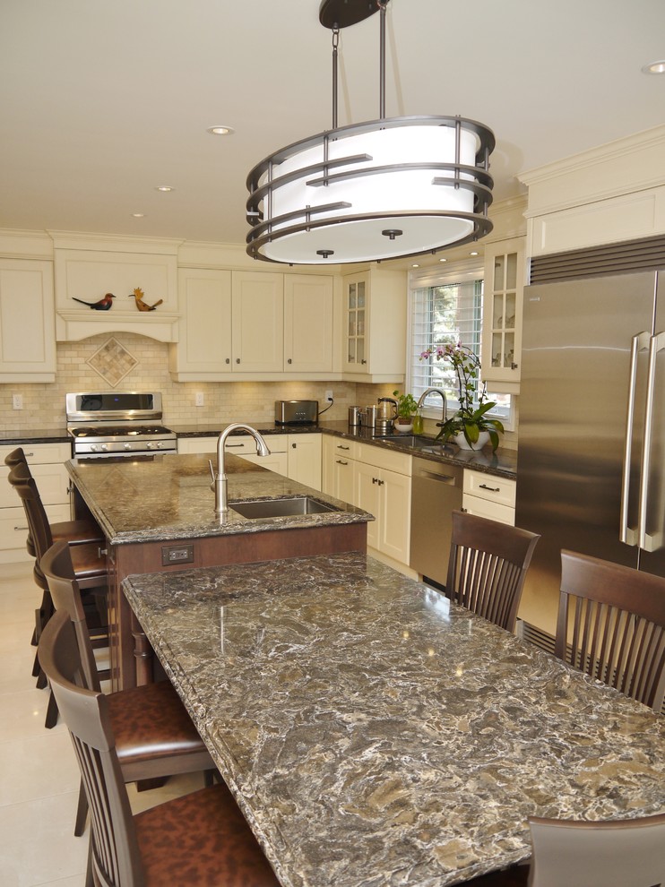 Mid-sized traditional l-shaped separate kitchen in Toronto with an undermount sink, recessed-panel cabinets, yellow cabinets, quartz benchtops, beige splashback, stone tile splashback, stainless steel appliances, porcelain floors and with island.