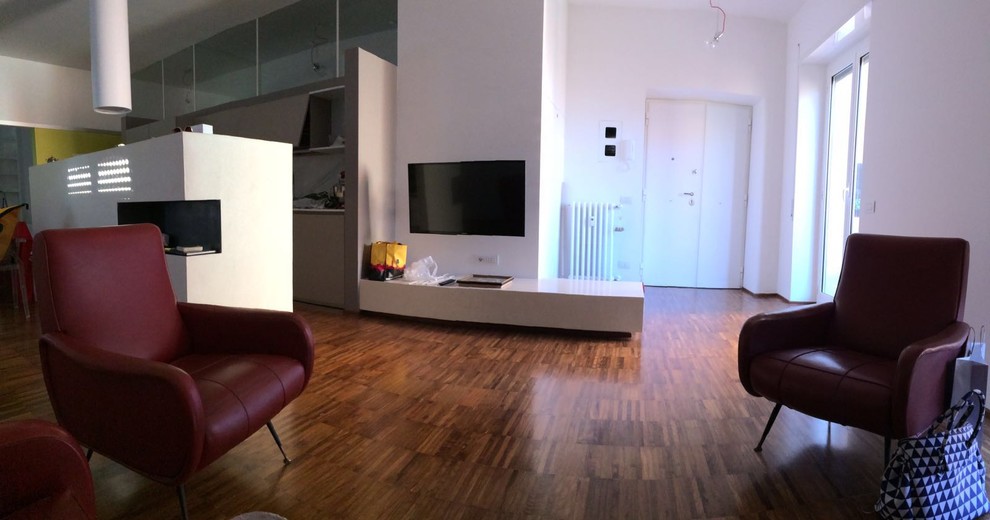 Ispirazione per un soggiorno minimalista di medie dimensioni e stile loft con pavimento in legno massello medio e TV a parete