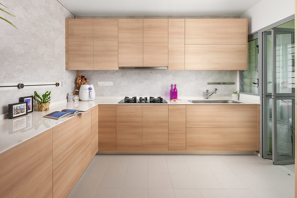 Design ideas for a contemporary l-shaped kitchen in Singapore with a single-bowl sink, flat-panel cabinets, light wood cabinets, grey splashback, no island, beige floor and white benchtop.