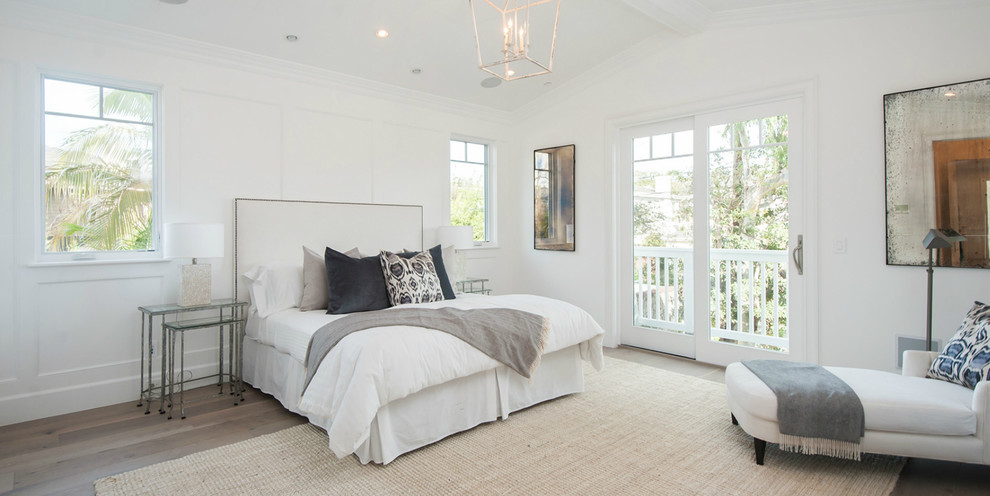 Large beach style master bedroom in Los Angeles with white walls.
