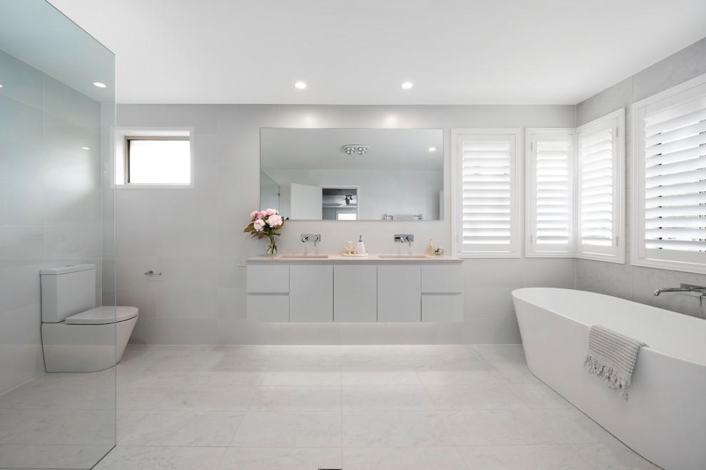This is an example of a large modern bathroom in Sydney with an open shower, a wall-mount toilet and an open shower.